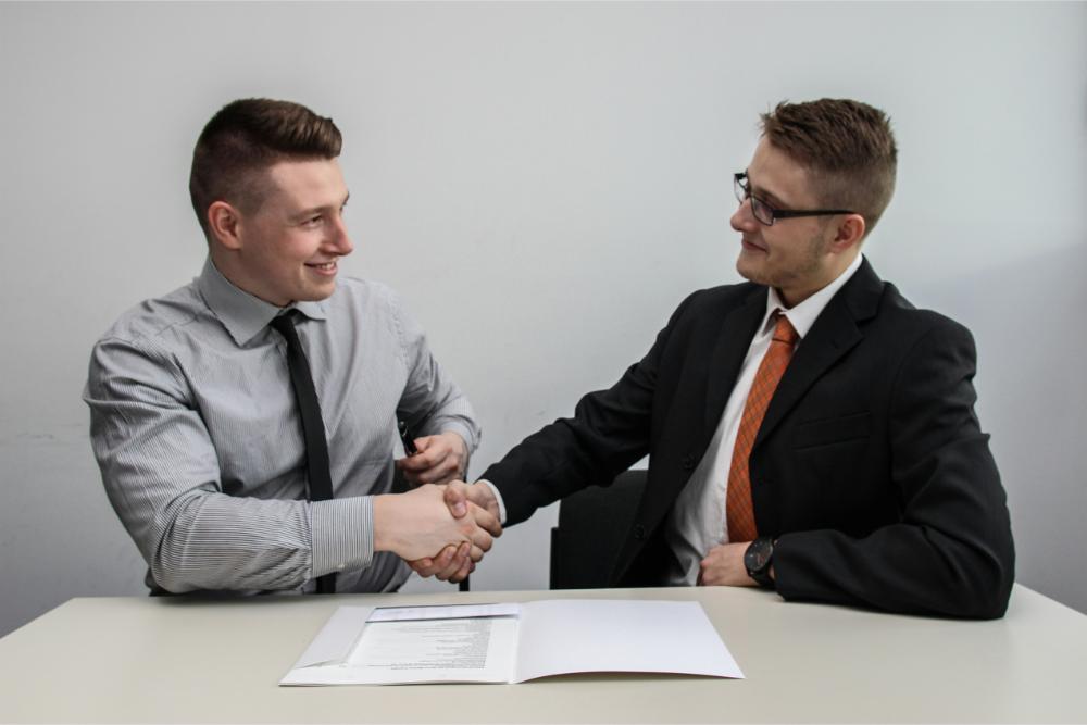 2 young professional men shaking each other's hands